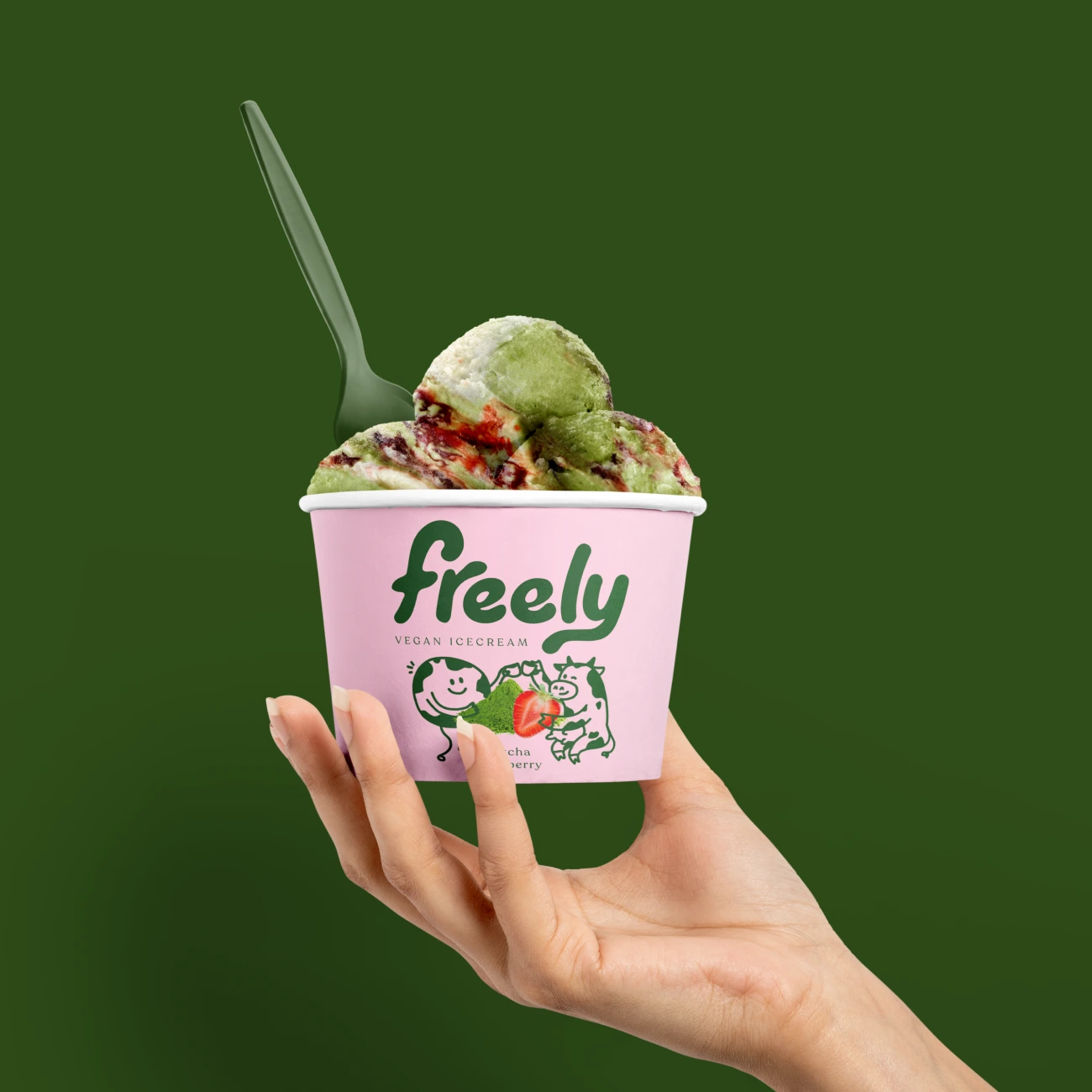Een hand houdt een Freely ijs cup Matcha Strawberry vast
